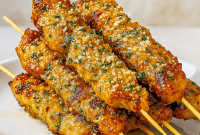Plate of juicy grilled ranch garlic parmesan chicken skewers served with dipping sauce and fresh parsley, a perfect example of garlic ranch chicken and one of the best quick chicken appetizers or appetizer chicken recipes for BBQs, parties, or weeknight meals.