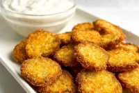 Golden brown Air Fryer Pickles served on a white plate with creamy ranch dip – the perfect Crispy Fried Pickles Snack for parties or easy weeknight munchies.