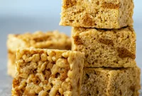 Stack of gooey Rice Krispie Treats made with cookie butter, crushed Biscoff cookies, and marshmallows — the ultimate Krispie Treats Recipe and one of the easiest Biscoff Recipes for chewy Cereal Treats and quick Easy Summer Desserts.