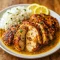 Spicy Brazilian coconut chicken simmered in a creamy sauce with red peppers, served over rice and topped with fresh cilantro.