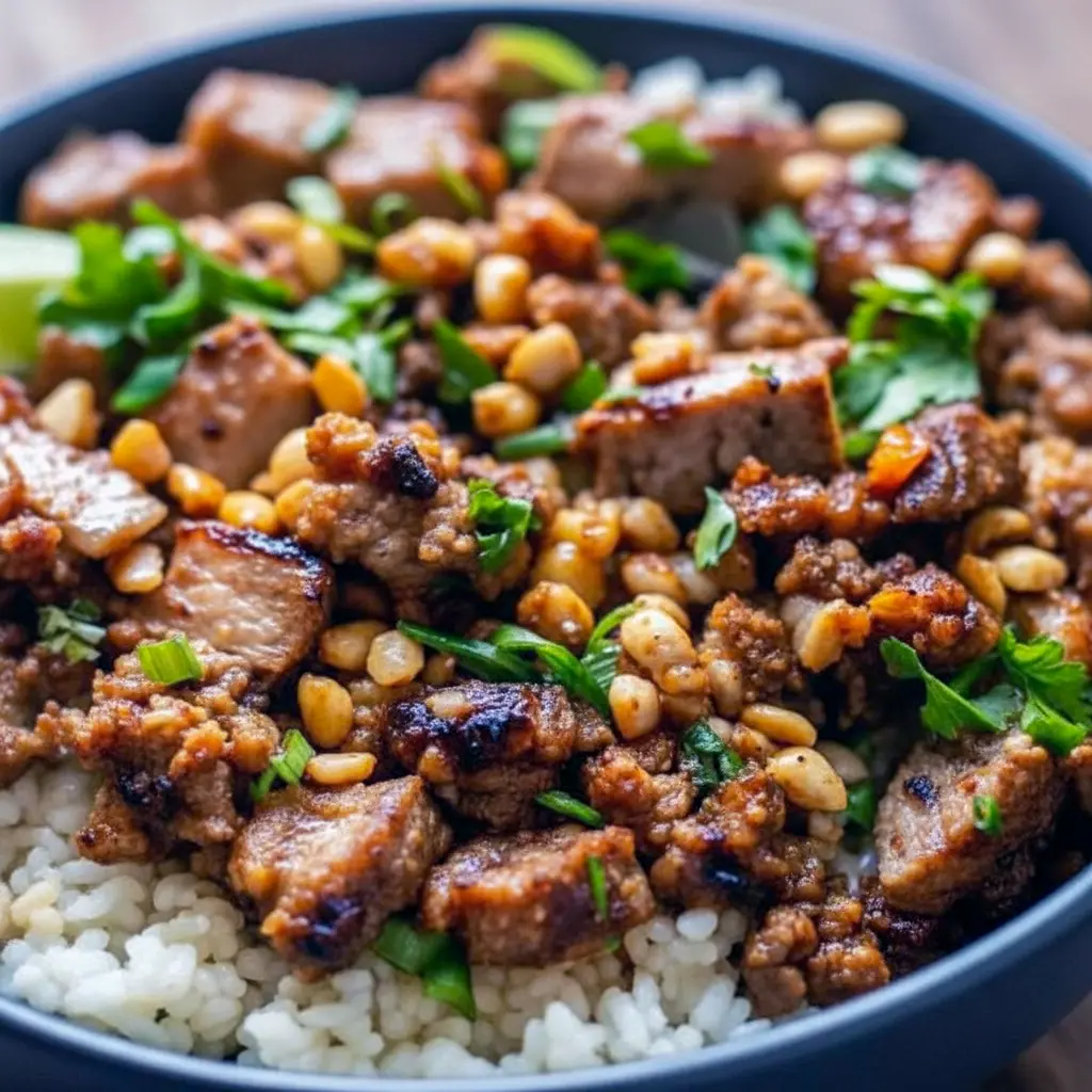 Close-up of glossy Ginger Lime pork medallions on fluffy jasmine rice with herbs and peanuts — a photo that screams Ginger Pork Recipes and perfectly represents creamy Coconut Rice Meals.