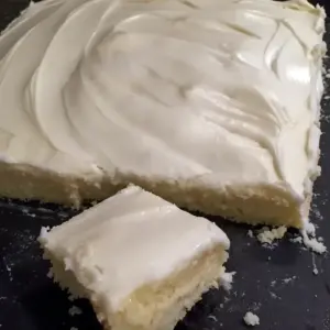 Almond Sheet Cake Recipe: Golden almond sheet cake in a greased Sheet Cake Pan, sliced like a Dessert Bar, topped with glaze, chopped nuts and mini Marshmallows, a tempting photo for fans of Sheet Cake Recipes, Almond Cakes, Food Cakes, Yummy Sweets and other Decadent Cakes.