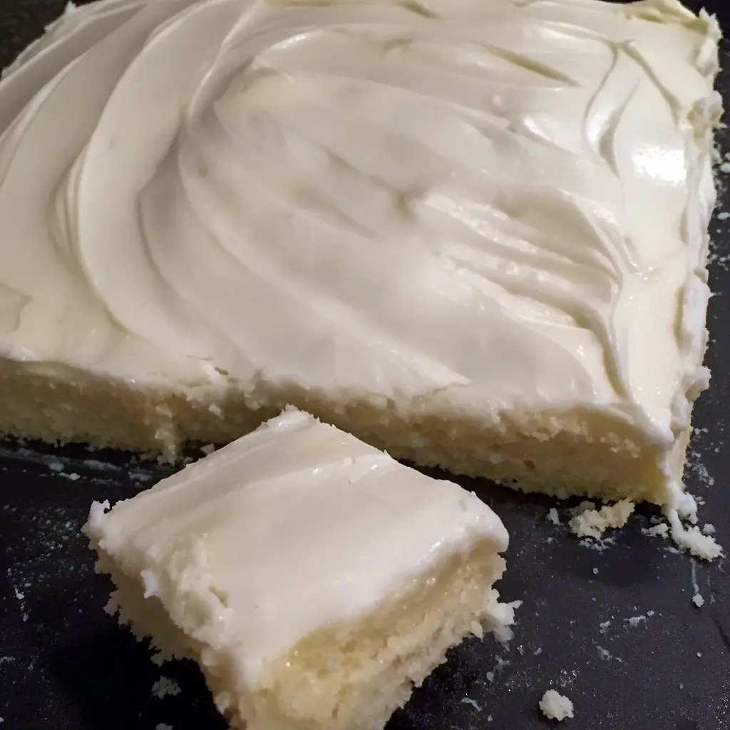 Almond Sheet Cake Recipe: Golden almond sheet cake in a greased Sheet Cake Pan, sliced like a Dessert Bar, topped with glaze, chopped nuts and mini Marshmallows, a tempting photo for fans of Sheet Cake Recipes, Almond Cakes, Food Cakes, Yummy Sweets and other Decadent Cakes.