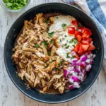 Pita piled with shredded Crockpot Chicken Schwarma Recipes, yogurt sauce, and herbs — a simple, healthy crowd-pleaser great for Crockpot Diet Recipes.