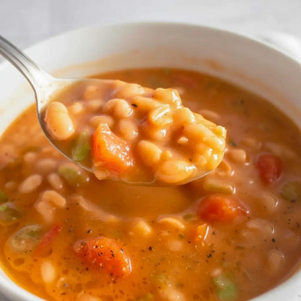 A bowl of Fasolatha, a traditional Greek Vegan Soup made with White Beans, tomatoes, and olive oil, served with rustic bread — a hearty comfort dish from Greek Recipes perfect for Soup And Salad lovers and fans of Здоровое Питание.
