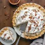 Close-up of a slice topped with whipped cream and toasted pecans: Creamy Pecan Pie Recipe on a flaky crust, shot from the side to show layers — the ultimate Pecan Cream Pie Recipe for festive gatherings.