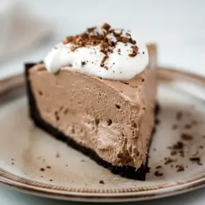 Dessert Parfait-style shot of a glossy chocolate pie slice topped with whipped cream and shavings, a tempting example of Keto Friendly Desserts and Low Carb Sweets, Low Carb Dessert.