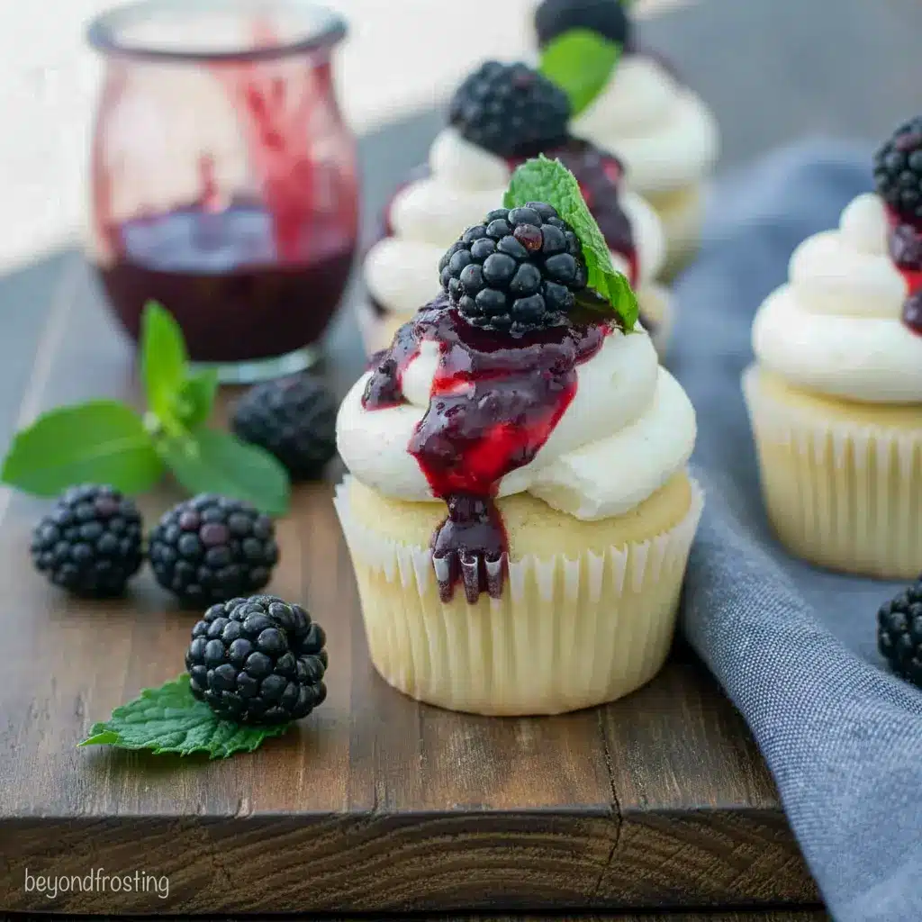 Close-up of a frosted cupcake with blackberry drizzle and a mint garnish — adult party treat for Liquor Desserts, ideal for Baking With Alcohol, and a top pick among Booze Desserts, Easy Alcohol Dessert Recipes.