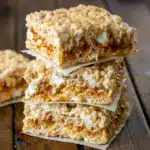 Close-up shot of brown butter dulce de leche Rice Krispie Treats, layered with gooey caramel and topped with extra marshmallows, creating soft, chewy Crispy Treats perfect for fans of gourmet Cereal Treats and Baking Sweets.