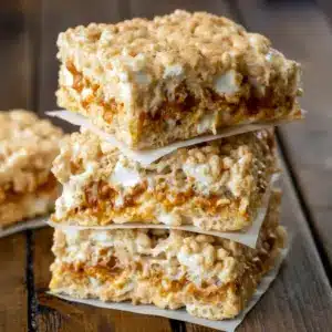 Close-up shot of brown butter dulce de leche Rice Krispie Treats, layered with gooey caramel and topped with extra marshmallows, creating soft, chewy Crispy Treats perfect for fans of gourmet Cereal Treats and Baking Sweets.