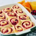 Glazed Orange Sweet Rolls on a platter — a cozy Holiday Baking scene ready for Thanksgiving Brunch; a bite shows jam, perfect Breakfast Sweets inspired by top Cranberry Recipes for Christmas Breakfast, a classic Sweet Roll for Breakfast Brunch Recipes or a Boulangerie display.