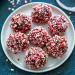 Close-up of glossy peppermint truffles coated in crushed candy cane and cocoa, arranged on a festive tray, Peppermint Truffles Recipe.