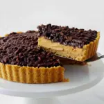 Slice of Chocolate Peanut Butter Crunch Pie showing creamy peanut butter filling and glossy chocolate crackle topped with crispy cereal — a dreamy Crunchy Crust Dessert.