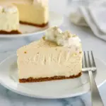 Slice of No Bake Eggnog Cheesecake with gingersnap crust, whipped cream, and a dusting of nutmeg.