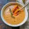 Cozy Soup — bowl of creamy roasted Italian sweet potato soup garnished with thyme and roasted potato wedges, ready to serve.