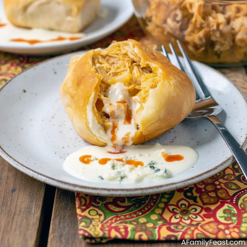 Easy Game Day Dinner Ideas: golden Buffalo Chicken Bombs on a platter, brushed with butter and served with blue cheese dressing and celery sticks.