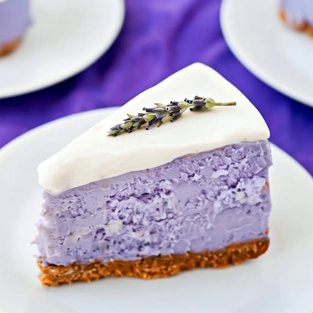 A slice of pale-violet cheesecake drizzled with honey and garnished with basil — a gorgeous Lavender Cheesecake Recipe photo that highlights Recipes Using Creamed Honey, pairs nicely with light Lavender Savory Recipes, and belongs in any Baking Recipes Lavender collection, Honey Lavender Cheesecake.