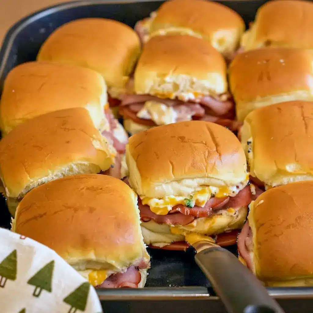 Golden, butter-brushed ham sliders on a wooden board, a perfect example of Sandwiches With Hawaiian Rolls, Sandwiches On Hawaiian Rolls, and easy Sandwich Recipes With Hawaiian Rolls, also adaptable for Sliders Cold Sandwich Recipes and served as a classic Sandwich On Hawaiian Rolls, Sandwiches Using Hawaiian Rolls.