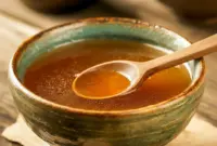Bowl of steaming Thai Bone Broth Recipe with cilantro and sliced chilies, ready to be poured into an Asian Soup bowl.