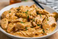 Close-up of shredded Crockpot Honey Mustard Chicken glazed in a golden honey-mustard sauce, garnished with parsley — a perfect example of Mustard Chicken Slow Cooker comfort food.