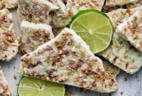 Protein Summer Recipes — frozen key lime yogurt bark pieces on parchment, topped with crushed graham crackers and toasted coconut, ready to grab from the freezer.