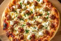 Close-up of a Specialty Pizza slice topped with crumbled feta, browned Italian sausage, thin red onions and a honey drizzle — a gourmet Fancy Pizza Toppings combo.