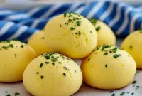 Savory Ricotta Recipes brought to life — close-up of golden ricotta egg bites in a muffin tin, topped with chopped chives and a lemon wedge, a perfect example of Egg Bites Easy for busy breakfasts.