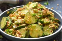 Bowl of Peanut Sauce Cucumber Salad: sliced cucumbers coated in spicy peanut dressing, topped with toasted peanuts and parsley — a bright Peanut Butter Lunch or side dish.