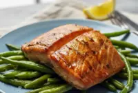 Close-up of Grilled Salmon fillet with glossy soy-brown sugar glaze, char marks, lemon wedge, and parsley — highlighting the Salmon Soy Sauce caramelization.
