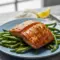 Close-up of Grilled Salmon fillet with glossy soy-brown sugar glaze, char marks, lemon wedge, and parsley — highlighting the Salmon Soy Sauce caramelization.