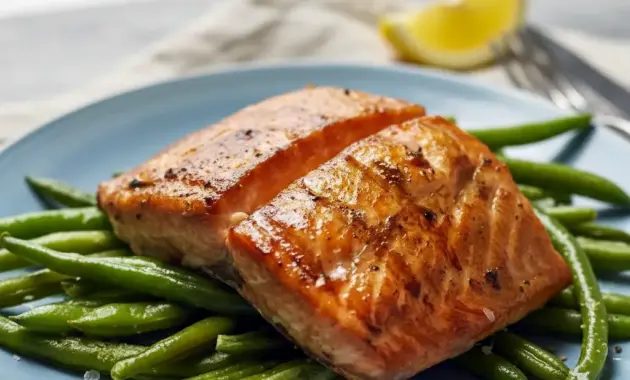 Close-up of Grilled Salmon fillet with glossy soy-brown sugar glaze, char marks, lemon wedge, and parsley — highlighting the Salmon Soy Sauce caramelization.