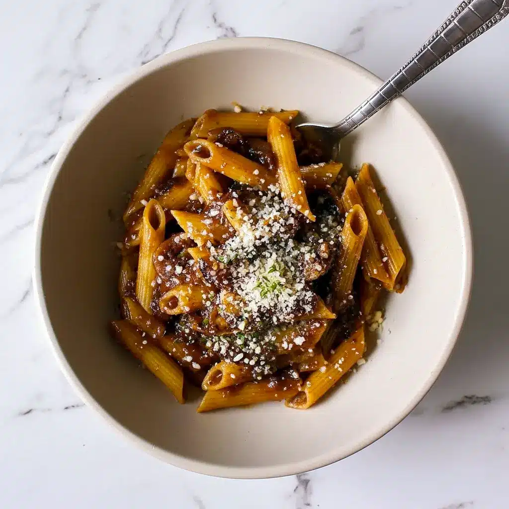 Close-up of Balsamic Mushroom Pasta coated in a glossy Balsamic Sauce For Pasta, finished with grated Parmesan and fresh thyme.