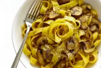 Close-up of a pappardelle bowl piled with golden, balsamic-glazed mushrooms and grated Parmesan — a hearty Mushroom Lovers Pasta shot highlighting a warm Vegetarian Pasta With Mushrooms serving.
