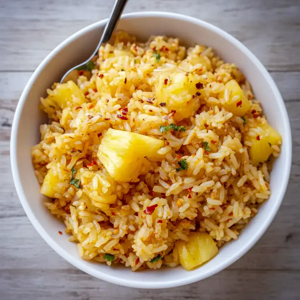 Pineapple Rice — close-up of coconut-scented rice studded with pineapple chunks, grated ginger, and green onions, served with a lime wedge.