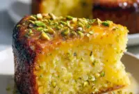 A slice of Lemon Pistachio Cake with lemon glaze and chopped pistachios — an easy Gluten Free Cake Almond Flour Recipe.