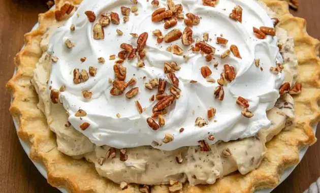 Slice of Pecan Cream Pie with whipped cream and toasted pecans on a plate — creamy filling and crunchy topping, a classic Pies With Cream Cheese dessert.