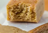 Tray of sliced Apple Protein Bars dusted with cinnamon, stacked and ready to grab for a quick breakfast.