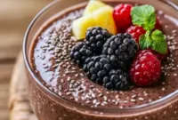 Chocolate Chia Pudding in a glass jar topped with raspberries and toasted almonds, creamy chocolate pudding texture visible.