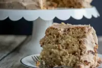 Banana Toffee Cake — slice showing banana-speckled crumb, glossy browned-butter toffee buttercream, and scattered toffee bits on top.