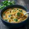 Warm bowl of Thai Potsticker Soup with tender dumplings, cilantro, and scallions in a creamy broth — a comforting Asian Soup shot.