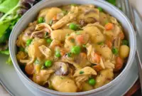Steaming bowl of One Pot Gnocchi Chicken Pot Pie with creamy sauce, chicken, peas, carrots, and pillowy gnocchi — a cozy Soft Foods Dinner and comforting Supper Tonight idea.