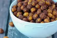 Cinnamon Roasted Chickpeas — golden, crispy chickpeas coated in cinnamon sugar and served in a rustic bowl; a close-up of Cinnamon Sugar Chickpeas ready to snack.