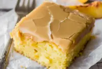 Brown Sugar Peach Cake in a 9x13 pan with tender yellow cake, fresh peach pieces, and a glossy brown sugar frosting on top.