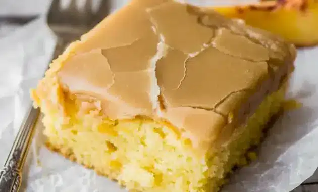 Brown Sugar Peach Cake in a 9x13 pan with tender yellow cake, fresh peach pieces, and a glossy brown sugar frosting on top.