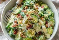 Cucumber Ceaser Salad: thin cucumber rounds coated in creamy Caesar dressing, topped with golden croutons and grated Parmesan.