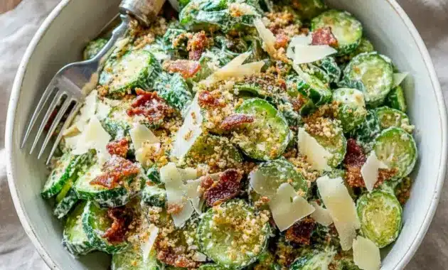 Cucumber Ceaser Salad: thin cucumber rounds coated in creamy Caesar dressing, topped with golden croutons and grated Parmesan.