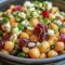 Bright bowl of Feta and Cranberry Chickpeas with crumbled feta, dried cranberries, chopped nuts, and herbs — a vibrant, ready-to-serve side salad.