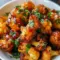 Close-up of glossy Maple Sriracha Cauliflower roasted to caramelized edges, sprinkled with sesame seeds — a standout in Cauliflower Recipes and an easy Veggie Side Dishes option.