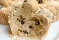 Close-up of three Cookie Dough Cups in paper liners: creamy yogurt base, little protein cookie-dough bites, and chocolate chips on top.