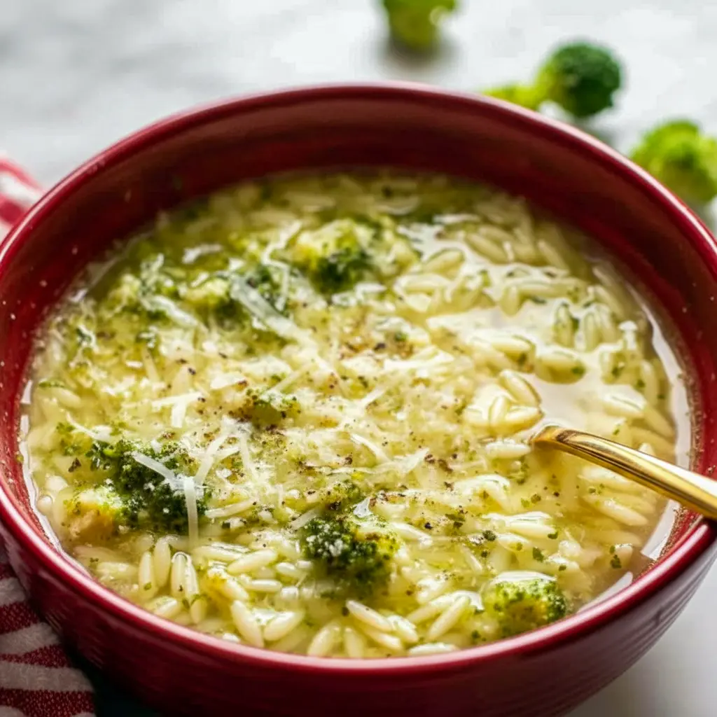 A bowl of Italian Broccoli Soup topped with parmesan cheese and olive oil, with tender broccoli, pasta, and garlic broth for a cozy homemade dinner.